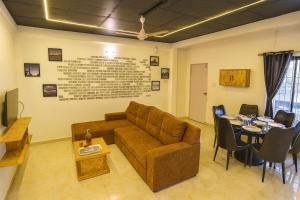 a living room with a couch and a table at EMPYREAN STAY 3BHK BLACK PANTHER VILLAll AC II PVT POOL II LUXURY ll in Lonavala +21 photos