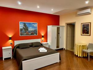 a bedroom with a bed and a red wall at Airport Rooms - Bari in Bari