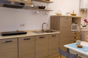 a kitchen with a sink and a microwave at Perca39 Casa nel cuore di Napoli, zona Sanità in Naples +7 photos