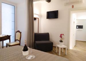 a room with a bed and a chair and a bottle of wine at Perca39 Casa nel cuore di Napoli, zona Sanità in Naples