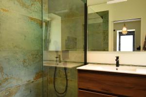 a bathroom with a shower and a sink and a mirror at VAUJANYLOCATIONS - Sert et Sagne 2 in Vaujany