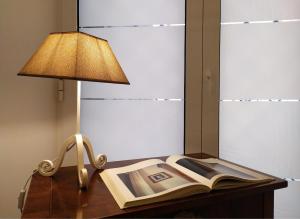 a lamp and an open book on a wooden table at Perca39 Casa nel cuore di Napoli, zona Sanità in Naples