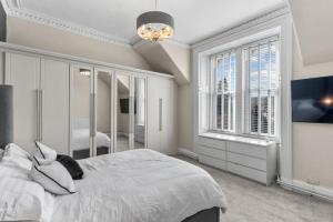 a white bedroom with a bed and a large window at Burnside in Rutherglen