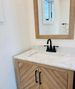un bagno con lavandino e specchio di Bright, Stylish 2BR, 2 Bath Near Beach with Outdoor Shower a Belmar