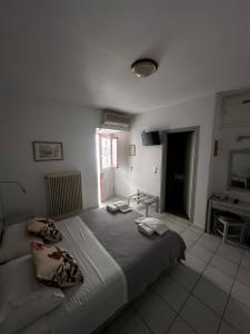 a bedroom with a large bed with two pillows on it at BAHIA Guest House in Hydra