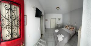 a bedroom with a bed and a red door at BAHIA Guest House in Hydra