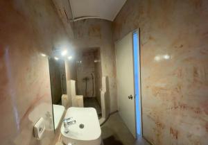 a bathroom with a white sink and a mirror at BAHIA Guest House in Hydra