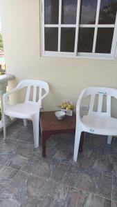 two white chairs and a table in a room at Habitación Taina in Jarabacoa