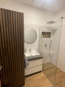 a bathroom with a sink and a shower with a mirror at Riverside Apartment Szeged in Szeged +12 photos