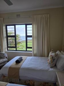 a bedroom with a bed and a large window at 13 Seaverge in Port Edward
