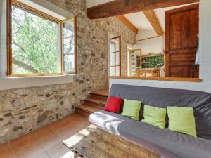 a living room with a gray couch with colorful pillows at Holiday Home in Tautavel near Gorges & Museum in Tautavel +17 photos