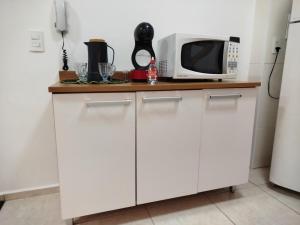 a kitchen with white cabinets and a microwave at Studio Premium in Franca +12 photos