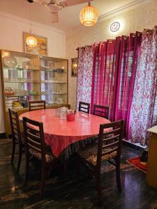 a dining room with a red table and chairs at Homestay near Kochi Airport in Ernakulam +7 photos