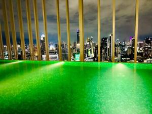 a view of a city skyline with green lights at Hyde Sukhumvit 11 Bankok in Bangkok