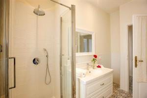 Un baño blanco con lavabo y ducha. en Villa Rachel Trilo, en Intra