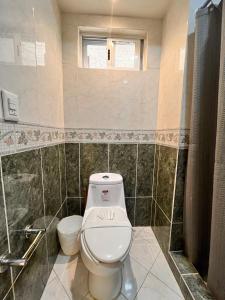 a bathroom with a toilet and a shower at Casa Bonampak 1 in Cancún