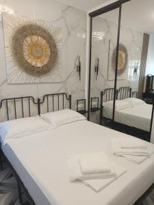 a bedroom with two beds and a large mirror at Olga Luxury Apartment in Paralia Katerinis