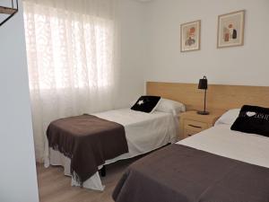 ロス・アルカサレスにあるModern 3 Bed House with shared pool in Los Alcazaresのベッドが2つと窓があるホテルの部屋