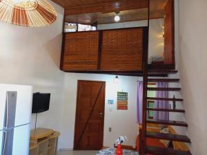 a loft bed in a room with a staircase at FLATS VASCONCELOS in Itacaré