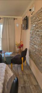 sala de estar con silla y chimenea de piedra en Deseo de Montaña, en Maipú