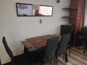 a dining room table with chairs and a mirror at Apartamento cerca al Aeropuerto in Bogotá
