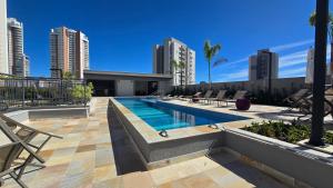 a swimming pool in a city with tall buildings at Studio em Sorocaba no Campolim in Sorocaba