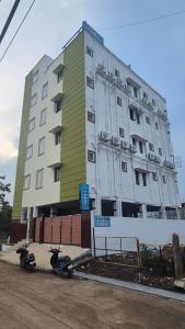 SiruseriにあるS R Guest Houseのスクーター2台が前に停まった建物