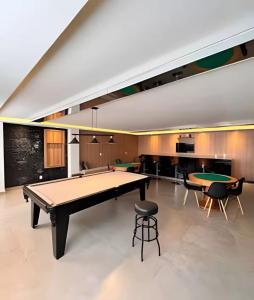 a room with a ping pong table and chairs at Studio Premium Zona Sul RP in Ribeirão Preto