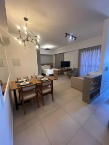 a dining room and living room with a table and chairs at Studio Premium Zona Sul RP in Ribeirão Preto