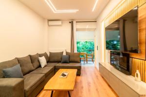 a living room with a couch and a flat screen tv at Cozy 2-Bedroom by Flisvos Marina in Athens
