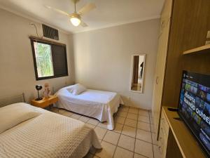 een slaapkamer met twee bedden en een flatscreen-tv bij Apto 237 super bem localizado in Ribeirão Preto +11 foto's