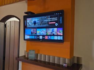 a flat screen tv on the wall of a room at Hotel Pousada Boa Montanha in Monte Verde