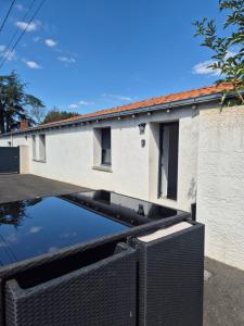 an external view of a building with a reflection in the water at La longère du Moulin in Basse-Goulaine