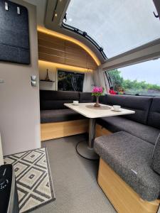 a train room with a table and a couch at Przyczepa ADORA nad morzem in Rumia
