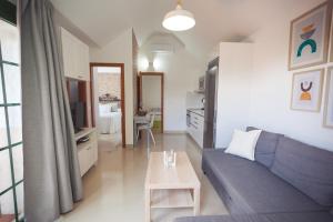 a living room with a blue couch and a table at Ahtha Green Bungalow Maspalomas in San Bartolomé de Tirajana