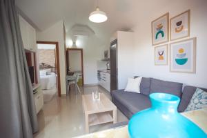 a living room with a blue vase in front of a couch at Ahtha Green Bungalow Maspalomas in San Bartolomé de Tirajana +53 photos