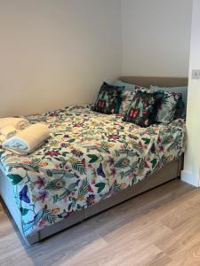 Una cama con un edredón y almohadas de colores en Ty Gwyn, en Troed-y-rhiw