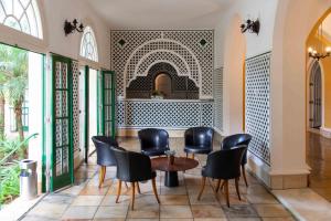a restaurant with black chairs and a table in a room at Hotel Glória Resort & Convention in Caxambu