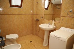 a bathroom with a toilet and a sink at Countryside Home in Poliçan +19 photos
