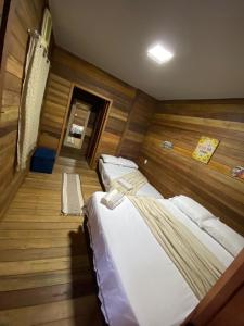 duas camas em um quarto com piso de madeira em Morada do Amor em Belém