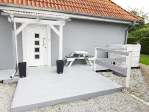 a white deck with a bench and a white door at Ferienwohnung Am Fischerhof 10a Wernigerode in Wernigerode