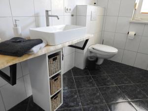 a bathroom with a sink and a toilet at Ferienwohnung Am Fischerhof 10a Wernigerode in Wernigerode +6 photos