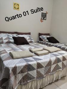 a bedroom with two beds with a comforter on it at Aparecida Confortável Apartamento in Aparecida +9 photos