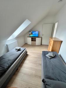 a attic bedroom with a bed and a tv at Oranienburg Unterkunft max 7P mit 4 Schlafzimmern in Oranienburg