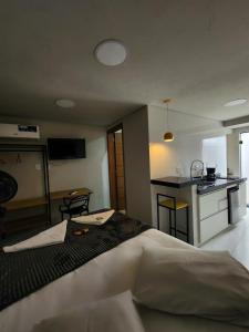 a bedroom with a large bed and a kitchen at Loft Moderno- Centro Histórico in São João del Rei