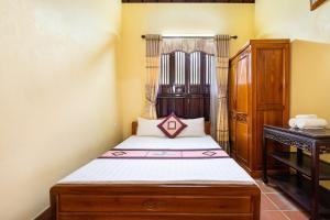 una piccola camera con letto e armadio in legno di Lumiere Family Village Ba Vì a Ba Vì
