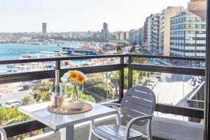 een tafel en stoelen op een balkon met uitzicht op de oceaan bij Top Location - 2BR Seafront & Steps from Ferry by ArcoBnb in Sliema