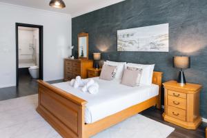 een slaapkamer met een groot bed met witte lakens en kussens bij Top Location - 2BR Seafront & Steps from Ferry by ArcoBnb in Sliema