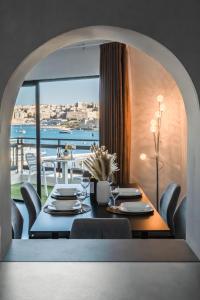 een eetkamer met een tafel en uitzicht op de oceaan bij Top Location - 2BR Seafront & Steps from Ferry by ArcoBnb in Sliema