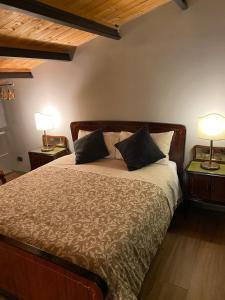 a bedroom with a bed with two lamps on two tables at Studio O F 2 in Leonforte